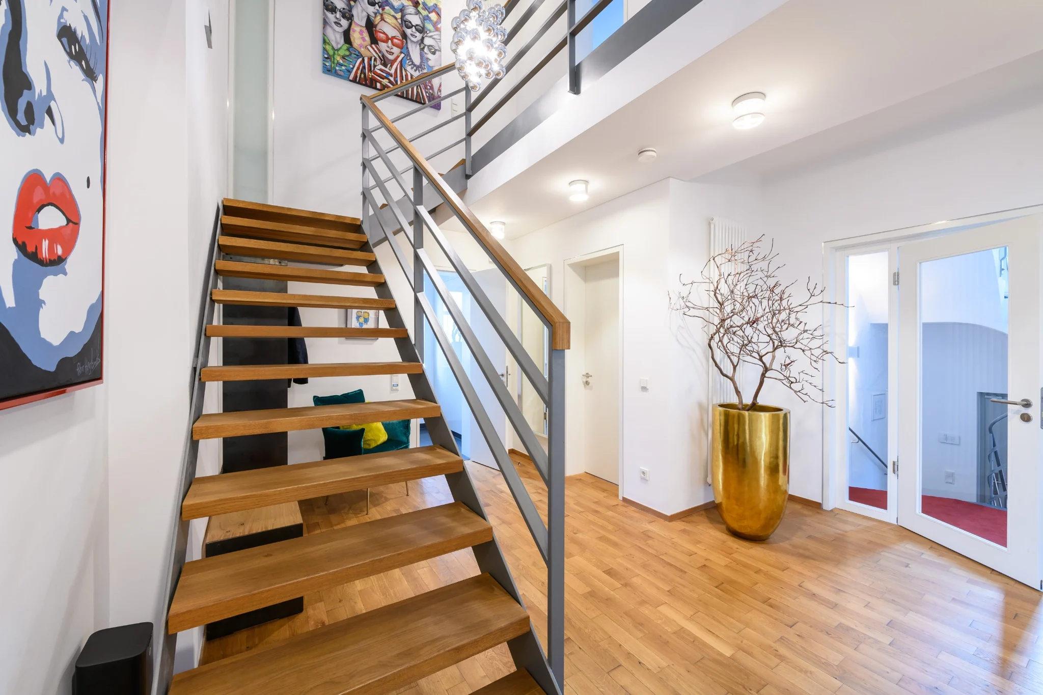 Hochwertiger Innenraum mit offener Treppe, Kunst und Materialkontrasten